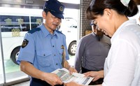 石鎚山の宿泊施設で登山の安全啓発のチラシを配る警察官